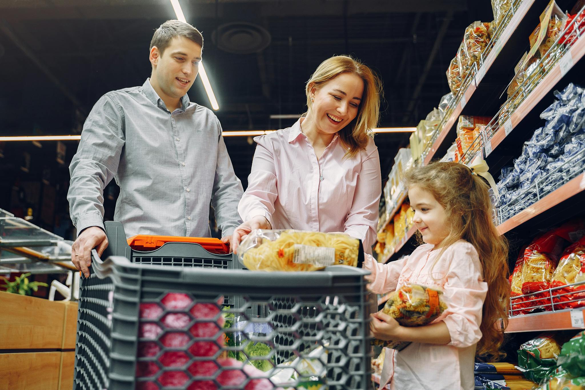 A joyful family of three shopping together in a supermarket, creating a memorable experience.